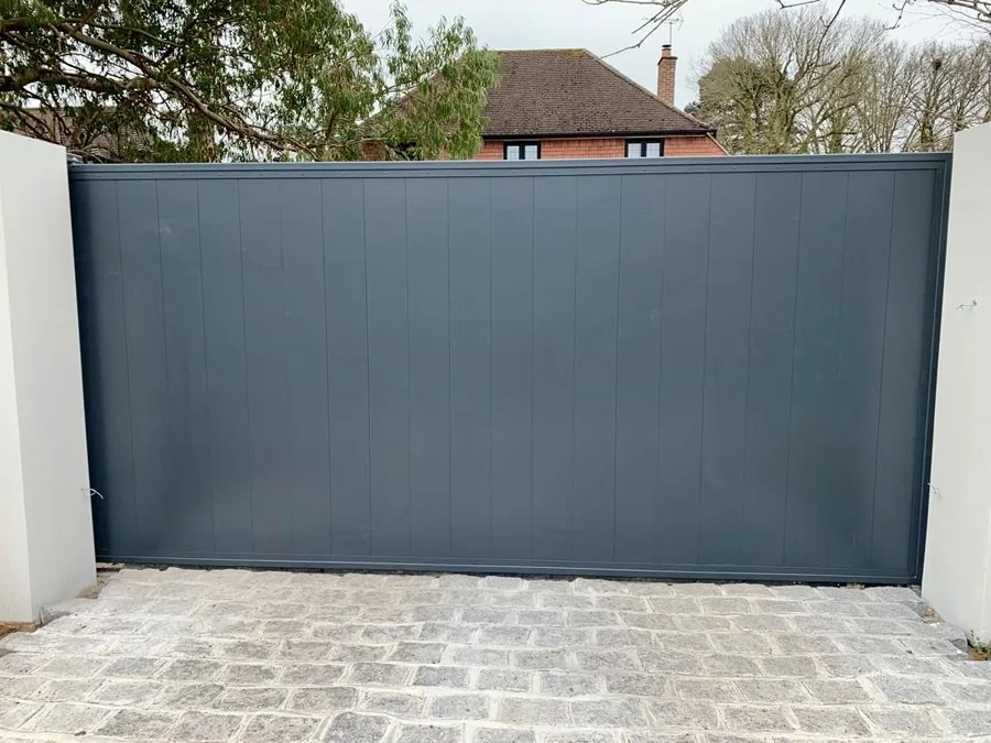 Solid dark grey metal driveway gate
