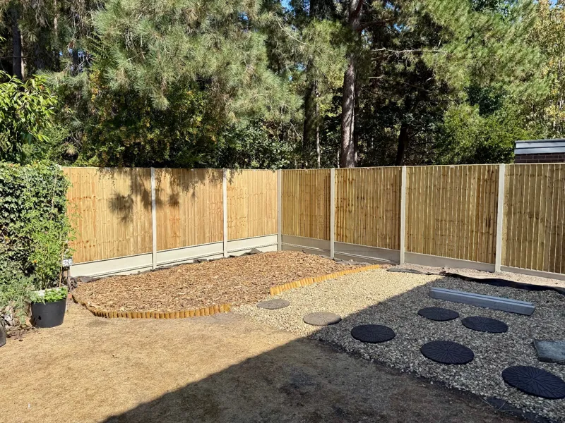Close board fencing around a landscaped garden with gravel paths