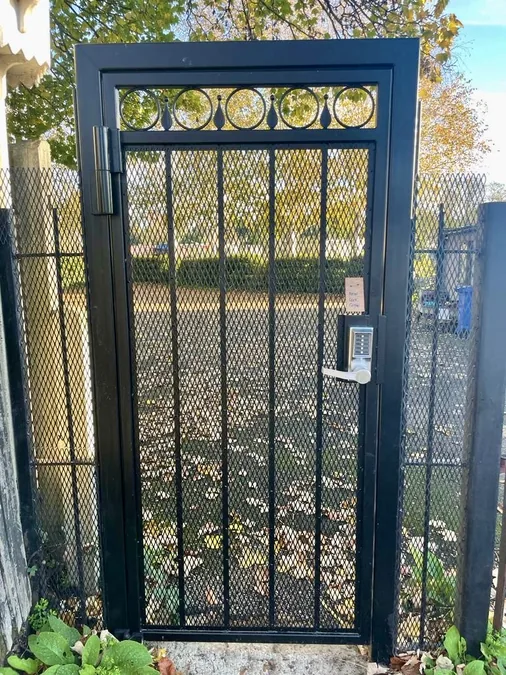 Black decorative mesh security gate with keypad lock