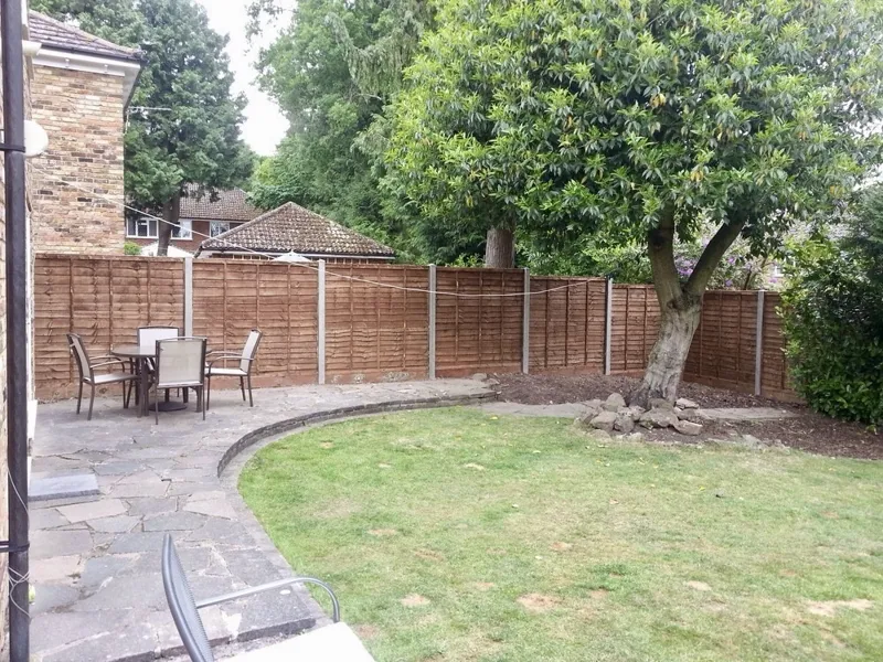 Waney lap panels on concrete posts around a patio garden