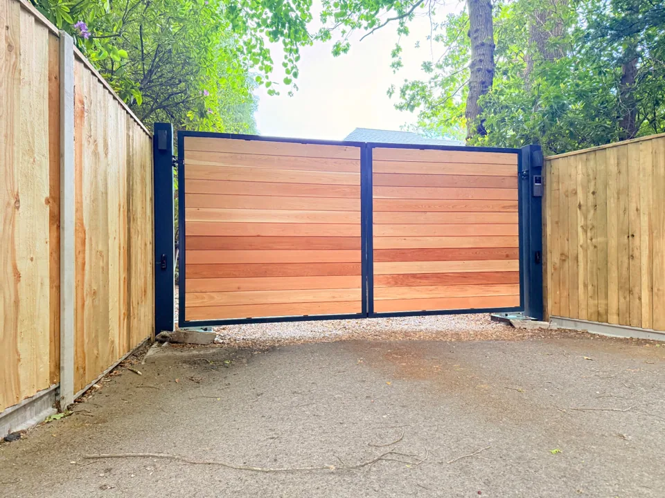 Double driveway gates with timber boards in a black metal frame