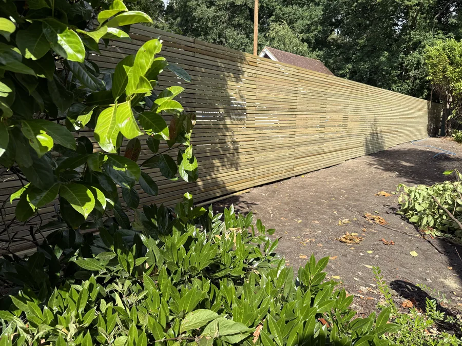 Close view of the continuous green timber slats and level capping rail