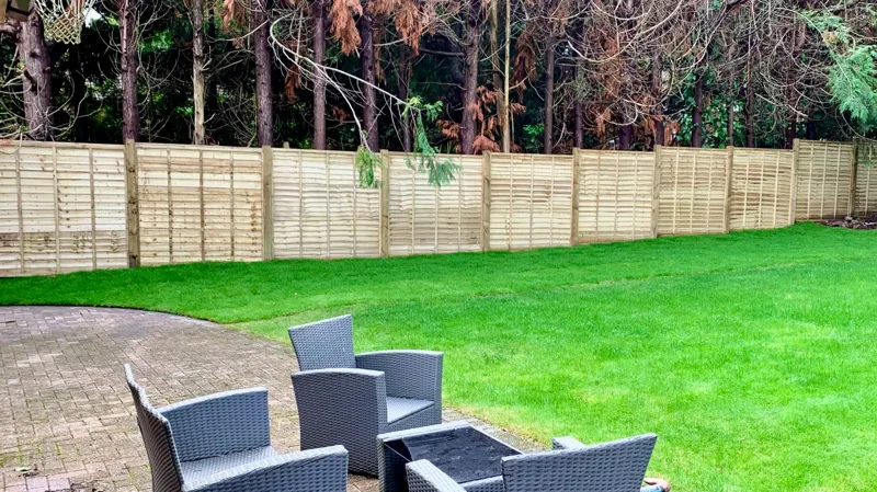 Overlap panel fencing on timber posts around a large lawn