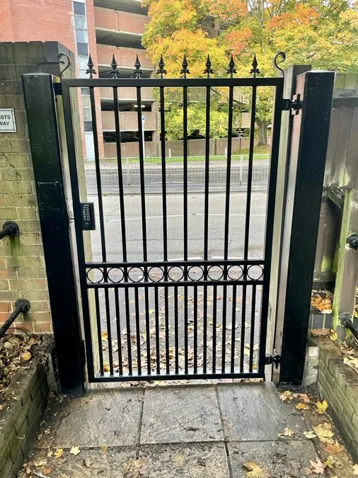 Black decorative pedestrian gate with keypad entry