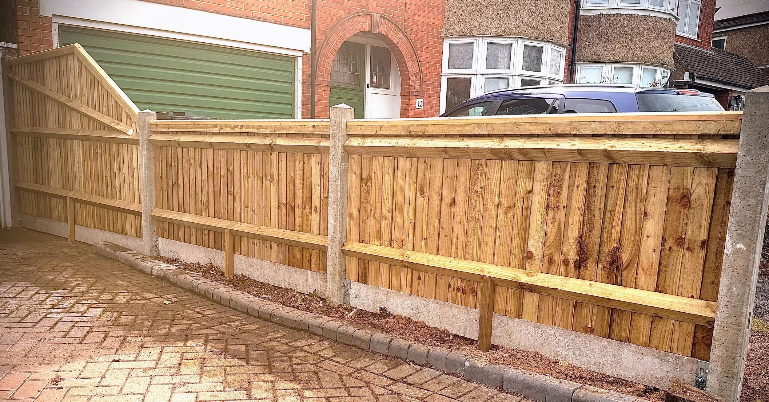 Close board fencing with concrete posts on a driveway boundary