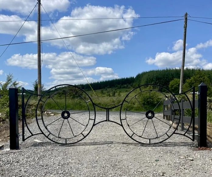 Bespoke black metal driveway gates with wheel design
