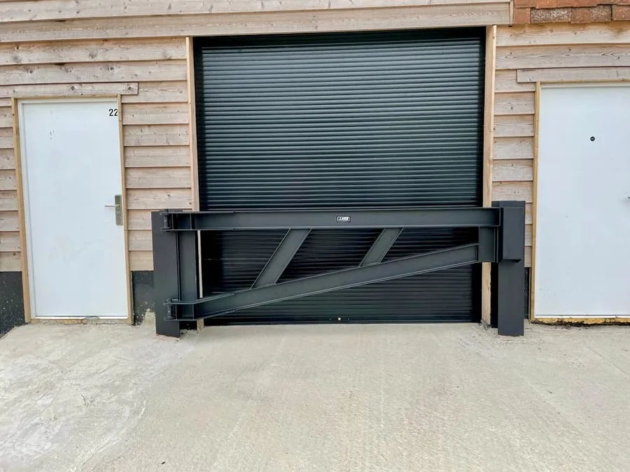 Black folding security gate fitted across a garage entrance