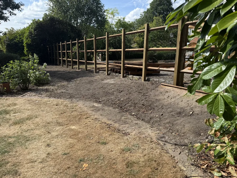 Reinforced timber post and rail framework along the cleared boundary