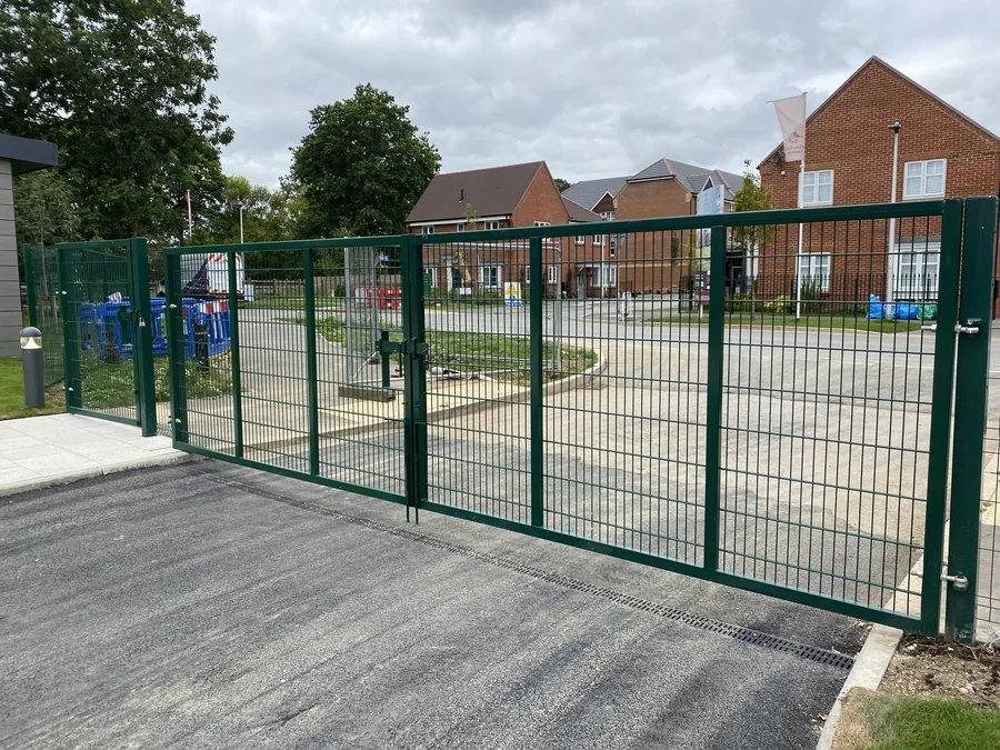 Large green mesh vehicle access gates forming part of the school perimeter