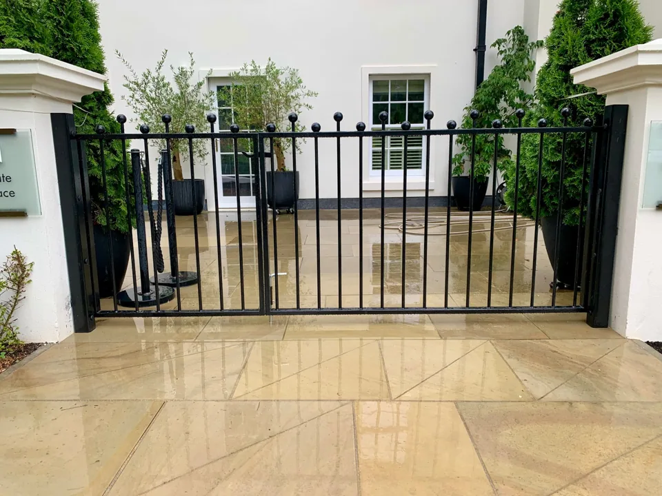 Black metal driveway gates with ball-top railings